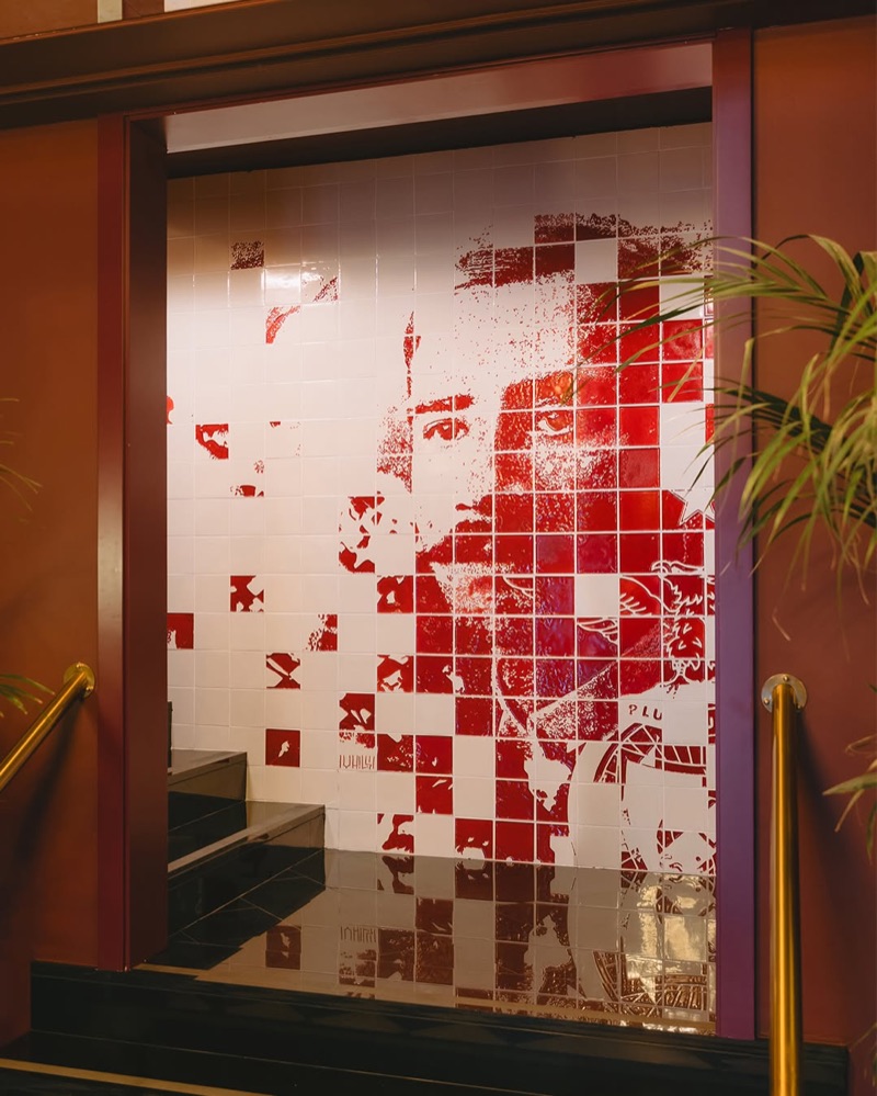Frontal view of the red-and-white carved-tile portrait mural of Cosme Damião at Hotel 1904 Benfica, Lisbon