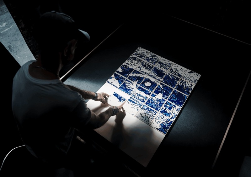 Vhils composing a carved cobalt-glaze Masterpiece panel in the Barreiro atelier