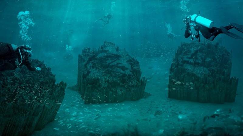 EDP Art Reef — divers over submerged carved-portrait dioramas