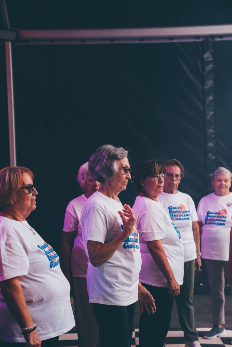Senior community performance group on stage — Bairros programme, 2024