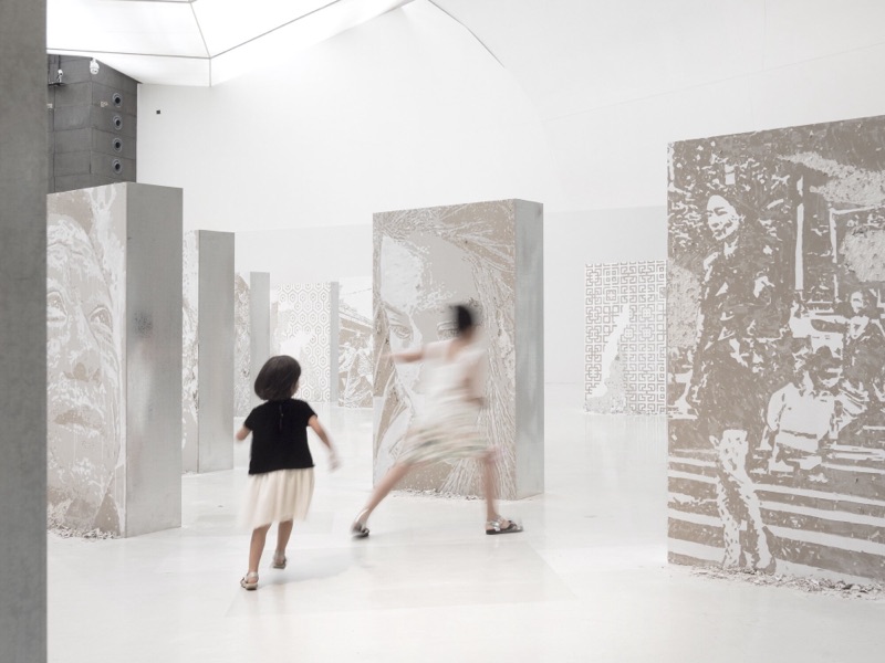 Children running past the carved panels at CAFA Art Museum, Beijing