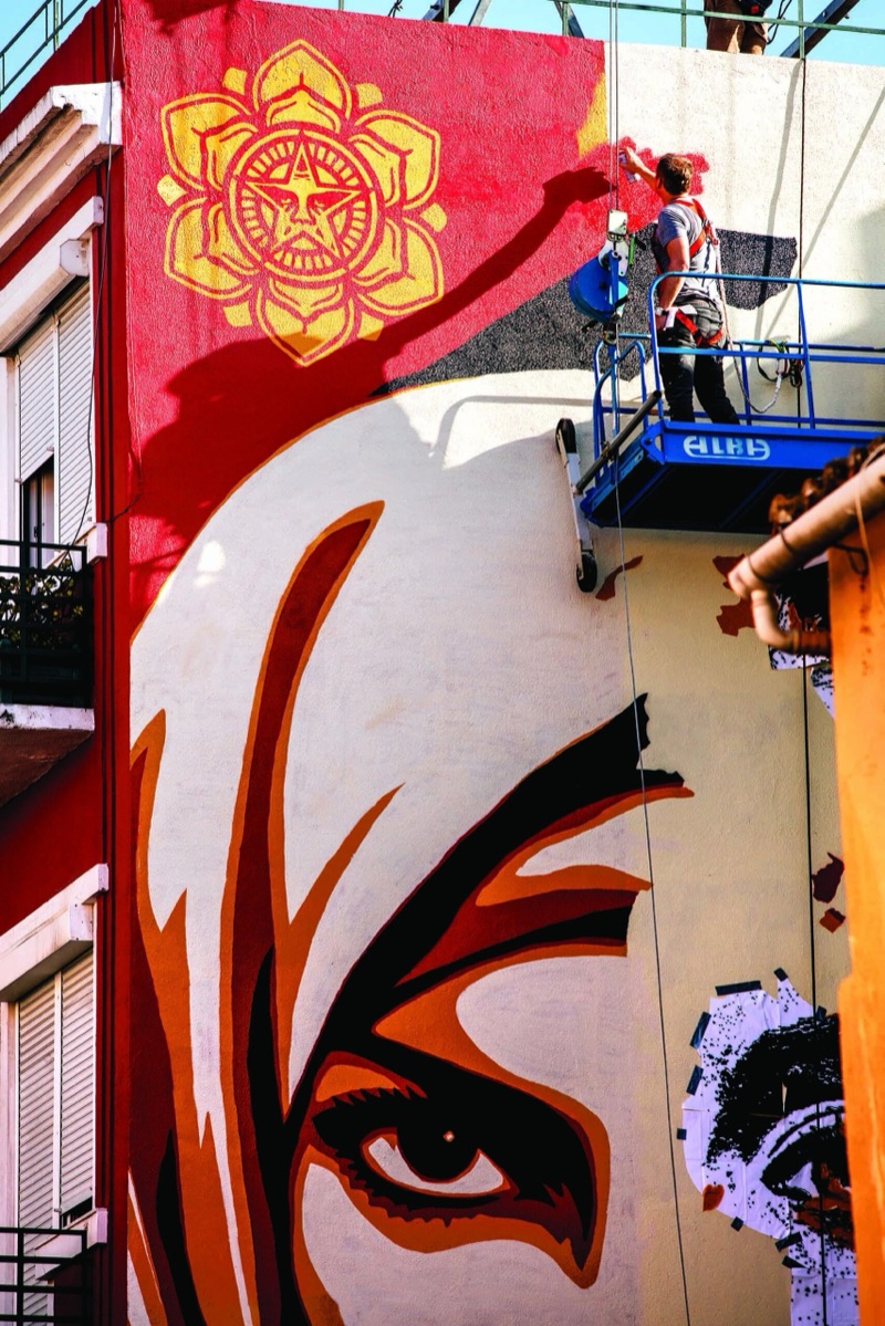 Shepard Fairey working from a cherry-picker on the Graça mural