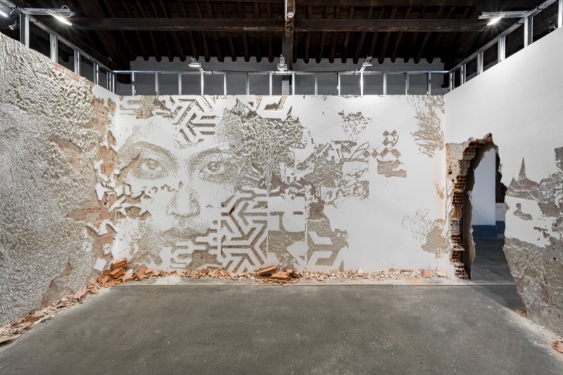 Urban (R)Evolution — Vhils carved-plaster wall room with bas-relief face and azulejo patterns, Cordoaria Nacional, Lisbon, 2023