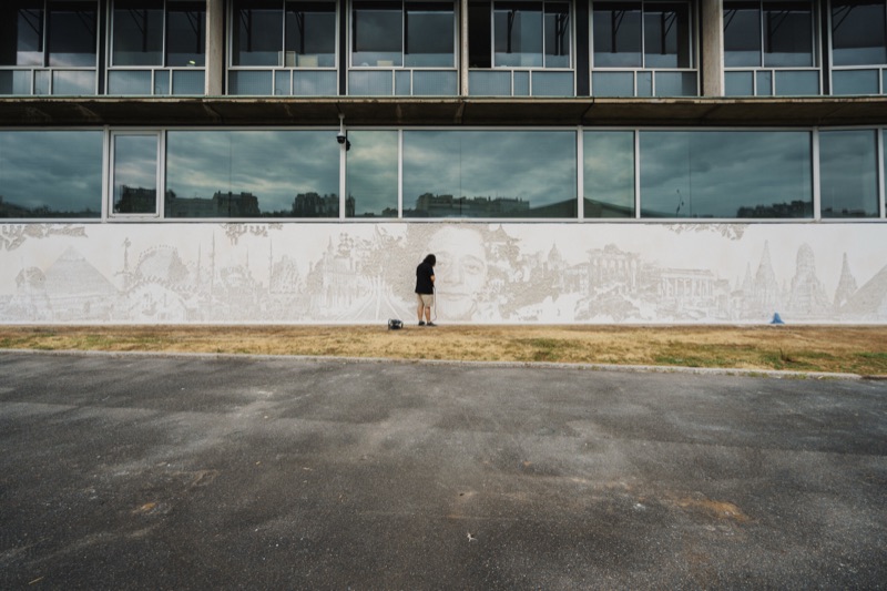 Full facade with the artist at work on the bas-relief