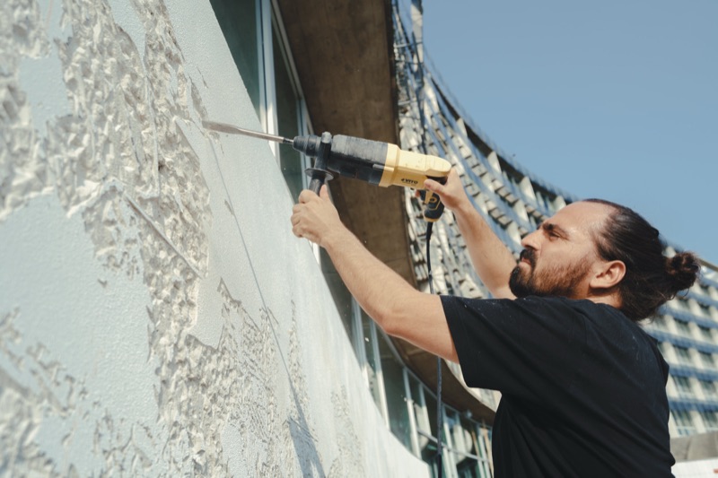 Detail of Vhils drilling the bas-relief
