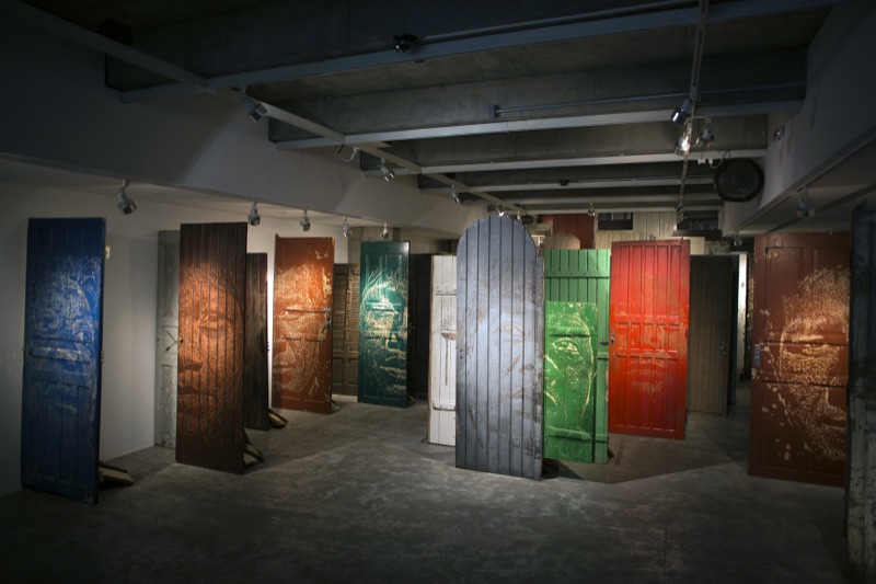 Installation of carved Guarani-portrait doors, CAIXA Cultural Curitiba